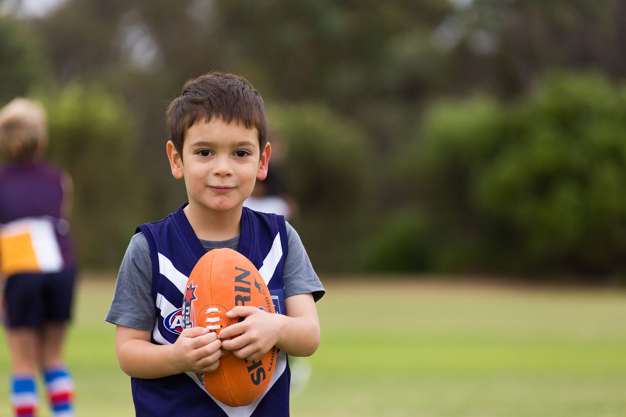 Photo of a young boy holding his football