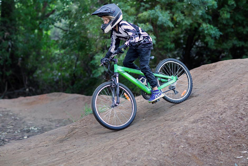 photo of a kid wearing bike gear riding a pushbike