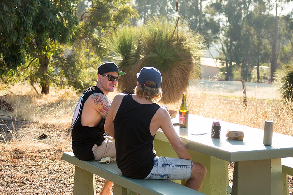Photo of two young blokes drinking outdoors