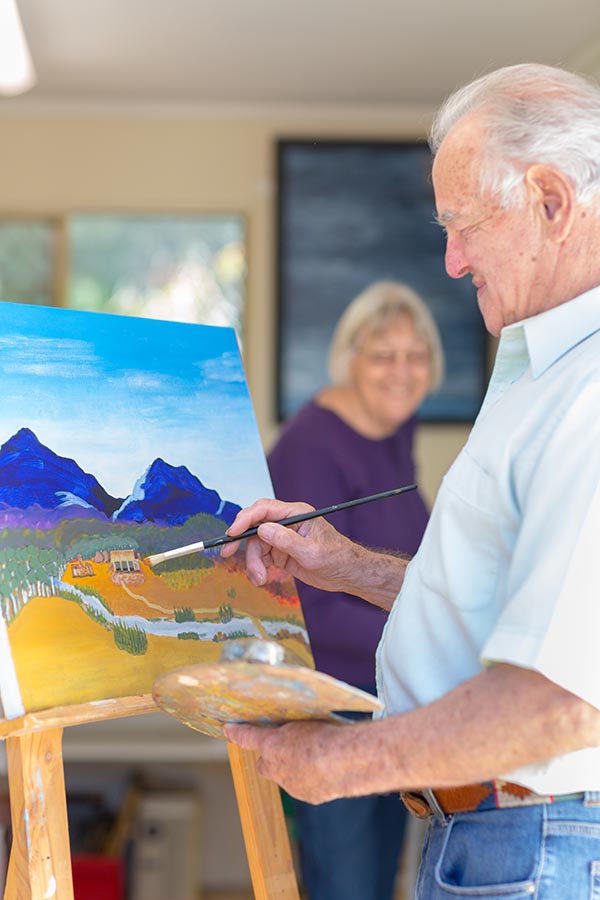 photo of an older couple painting in art studio. photo by Caro Telfer.