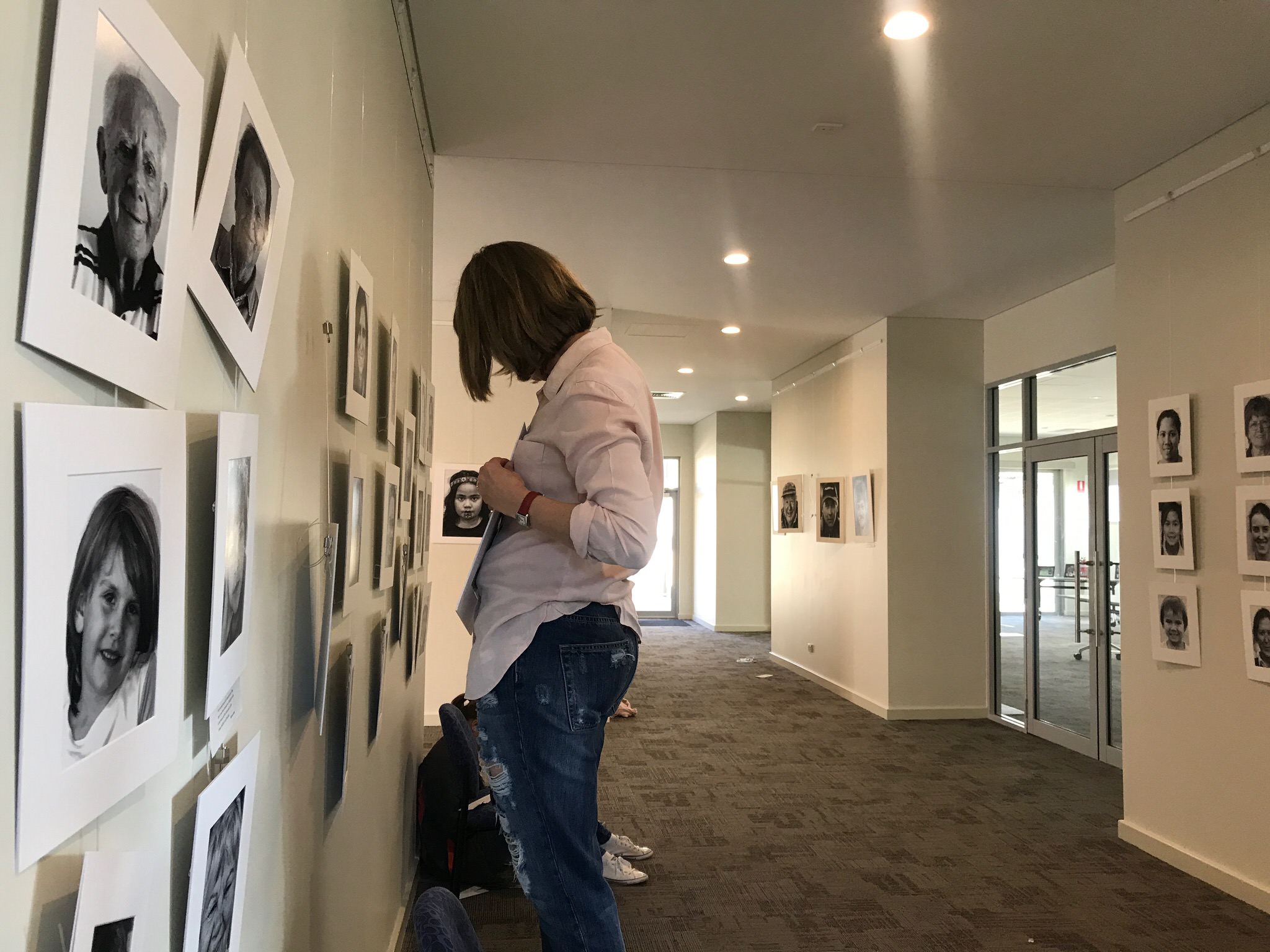 Photo of woman hanging photos in the exhibition