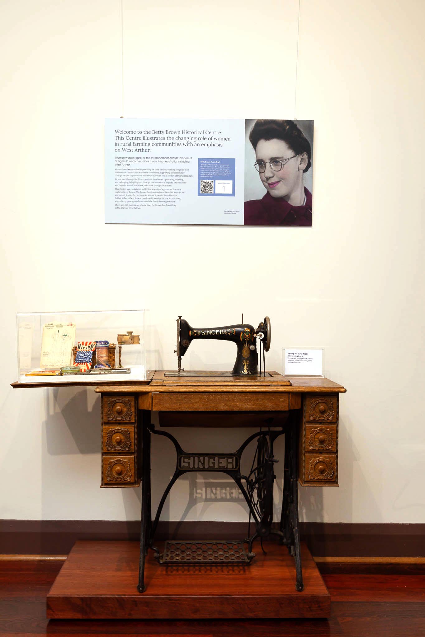 museum display of treadle sewing machine and interpretive panel