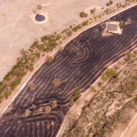 Aerial view of burnt stubble paddock in landscape